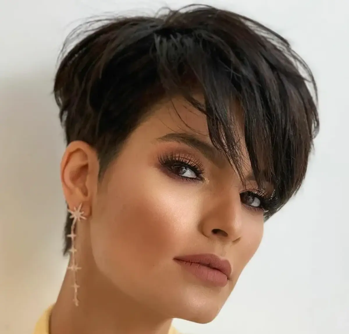 dark-haired woman with pixie cut and long bangs how to get this cut
