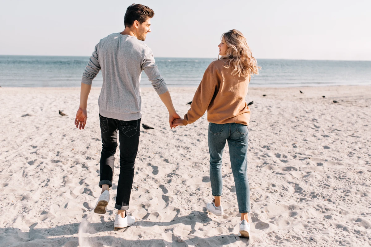 homme et femme qui se tient la main plage couple