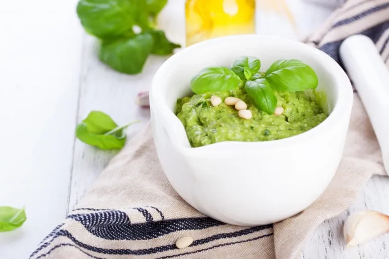 preparation recette pesto feuilles basilic noix bol blanc serviette beige