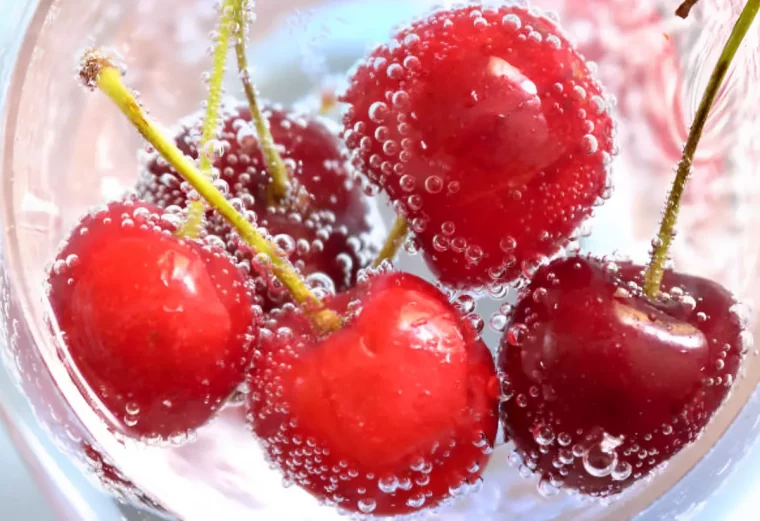 quelques cerises dans un verre avec un liquide vue de dessus