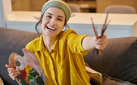 femme sourire canape peinture outils palette chemise jaune moutarde