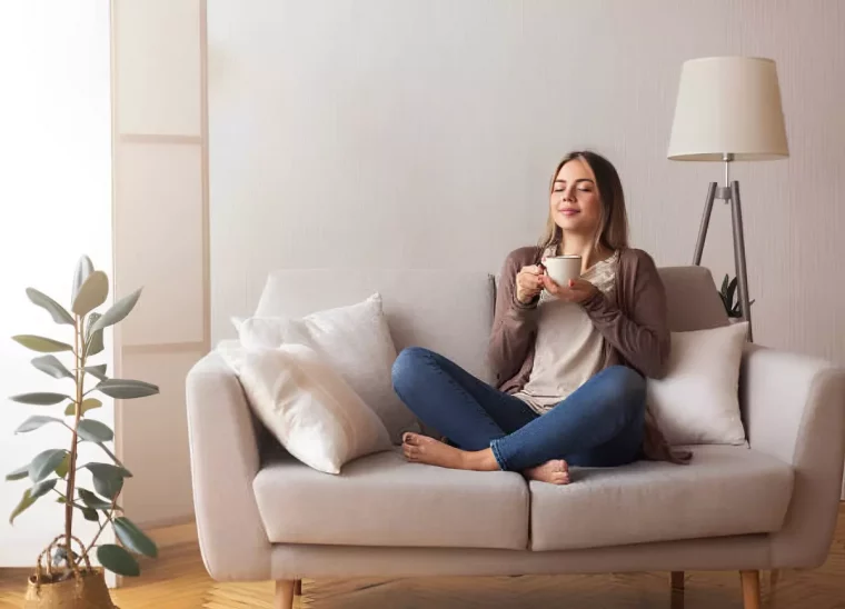 femmes aux yeux fermes assise avec les jambes croisees sur un canape deux places