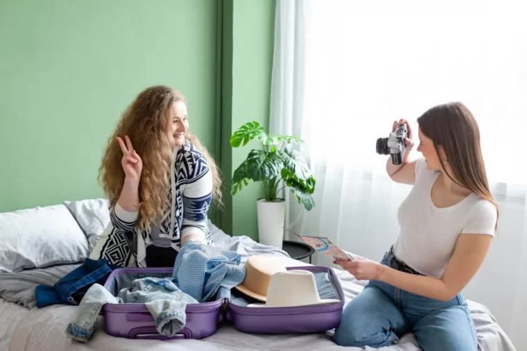 femmes chambre verte plante monstera bagage valise lit vetements capeline appareil photo