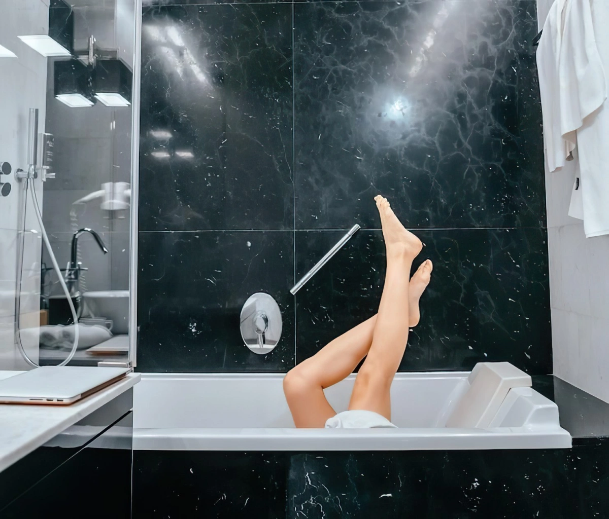 jambes pieds salle de bain carrelage noir baignoire douche inox