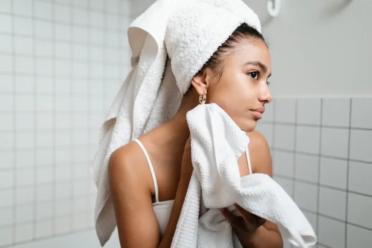 serviette de bain cheveux mouilles carrelage blanc salle de bain nettoyage visage
