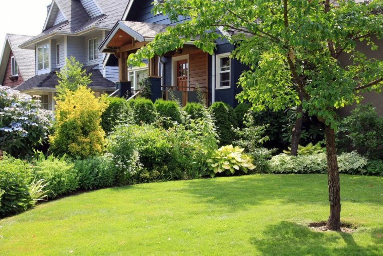 beautiful home surrounded by a lush perennial front garden.