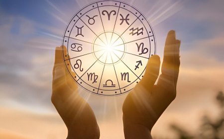 le cercle des douze signes astrologiques tenu entre les mains sur fond du disque solaire dans le ciel