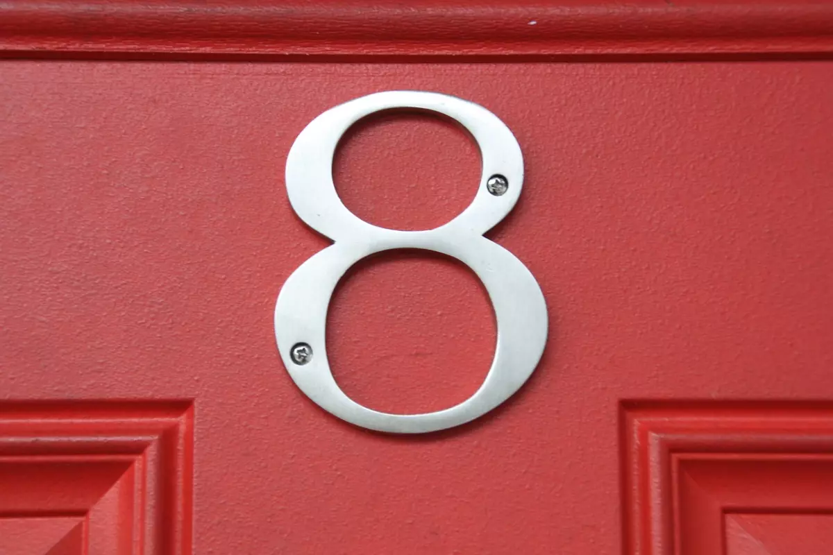 chiffre huit en metal sur une porte rouge