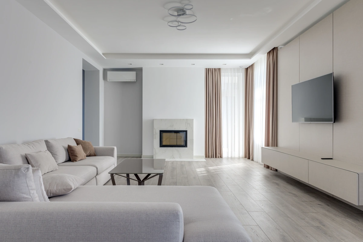 climatisation salon blanc plafond suspendu canape d angle meuble tv cheminee rideaux sol bois blanc