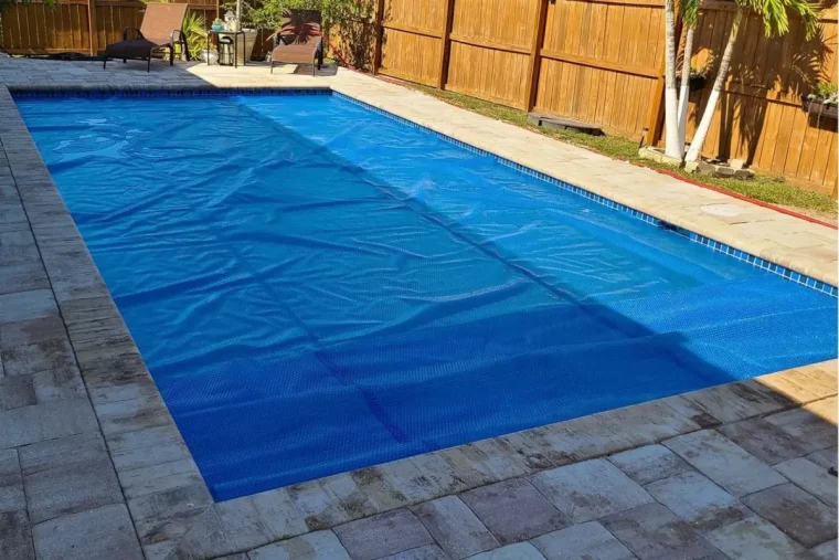 couverture bache toile bleue revetement sol autour piscine pierre dalles