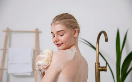femme blonde eponge bain eau savonneuse plante verte robinet