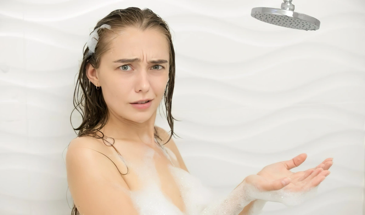 femme brunette cheveux mouilles eau savonneuse douche carrelage