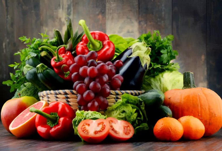 fruits et legumes dans un panier sur fond du bois