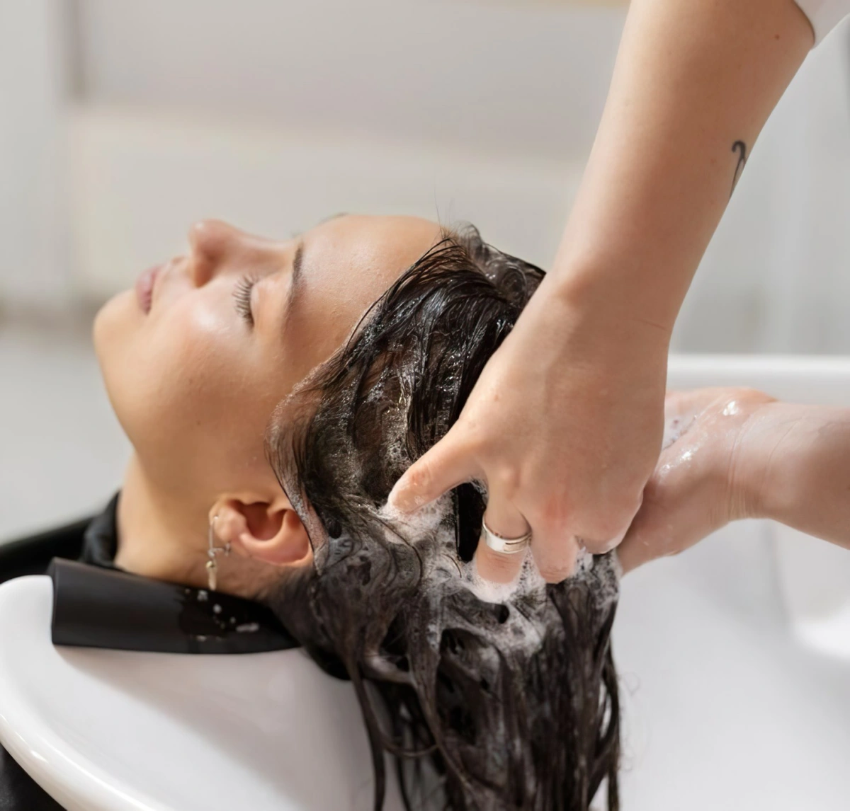lavage cheveux mains femme massage cuir chevelu eau savonneuse