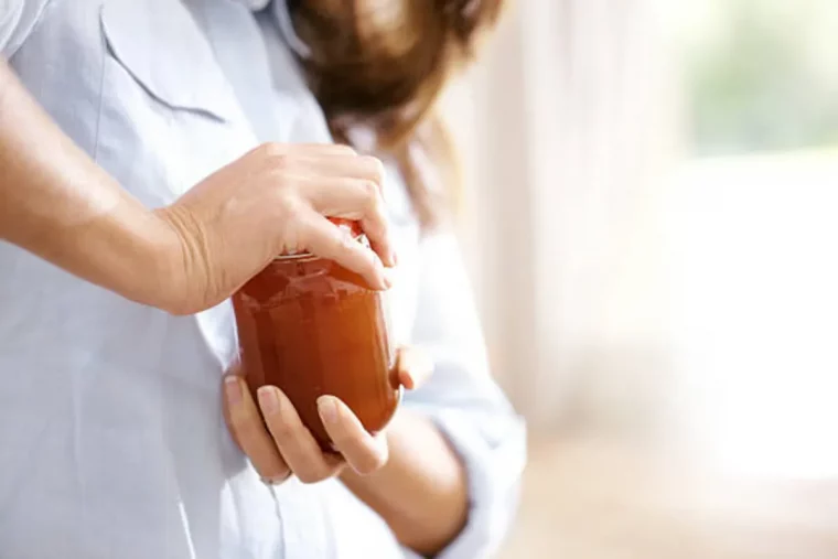 ouvrir un pot de confiture trop ferme femme deplie couvercle