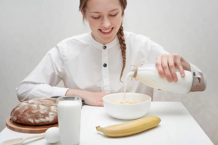 petit dejeuner cereales lait verre oeuf banane pain table blanche