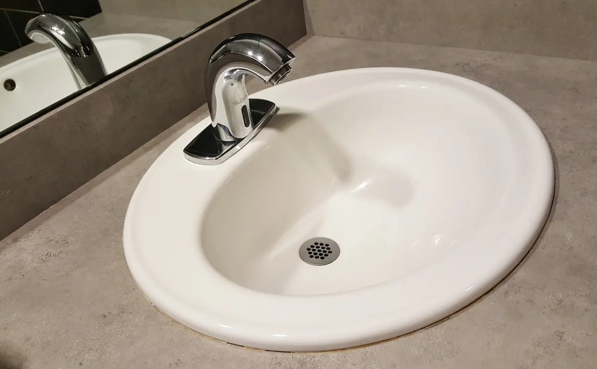 salle de bain robinet inox comptoir pierre lavabo blanc bouchage drain plomberie en bonne sante