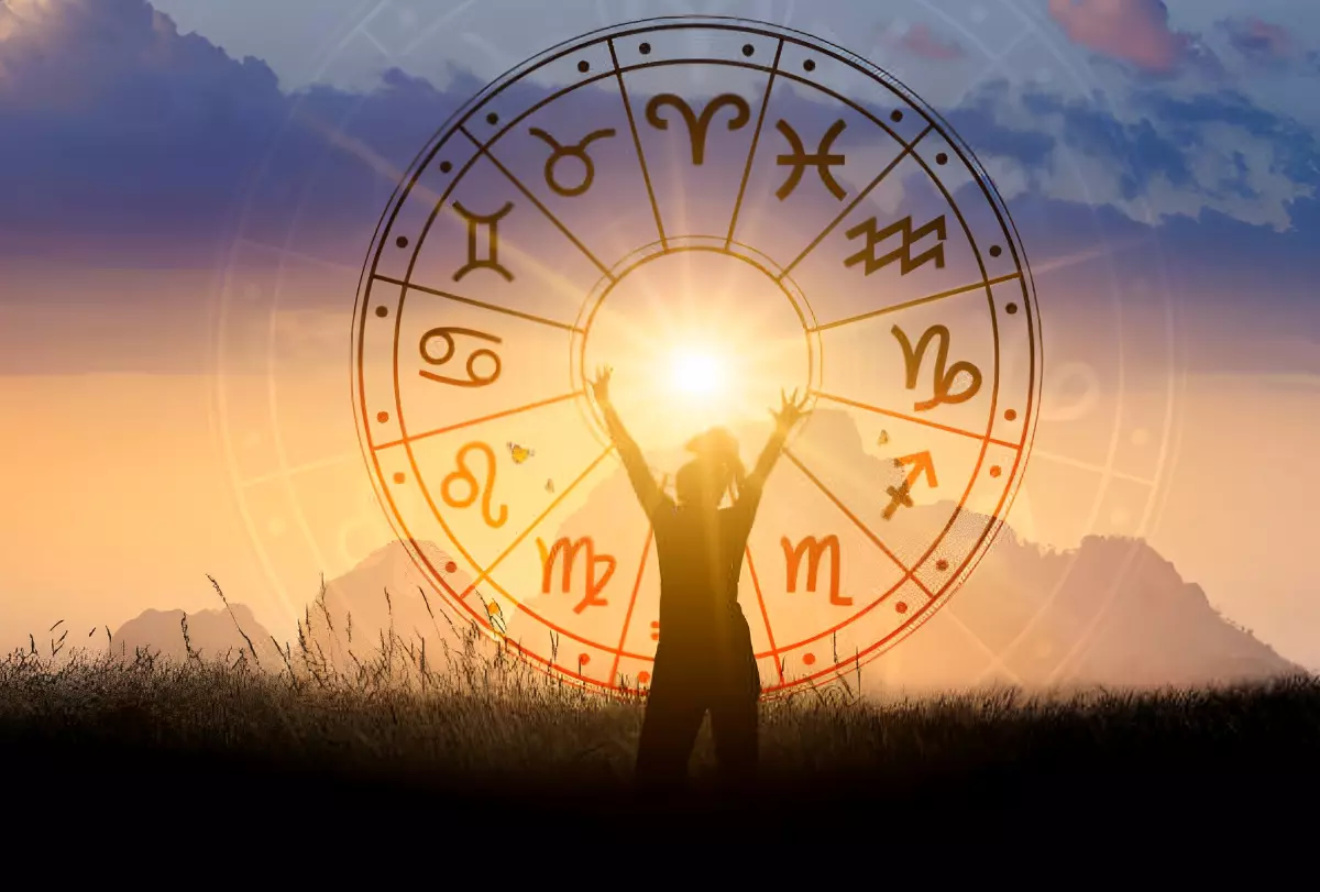 silhouette d une femme avec les mains levees devant le zodiac avec le soleil au centre