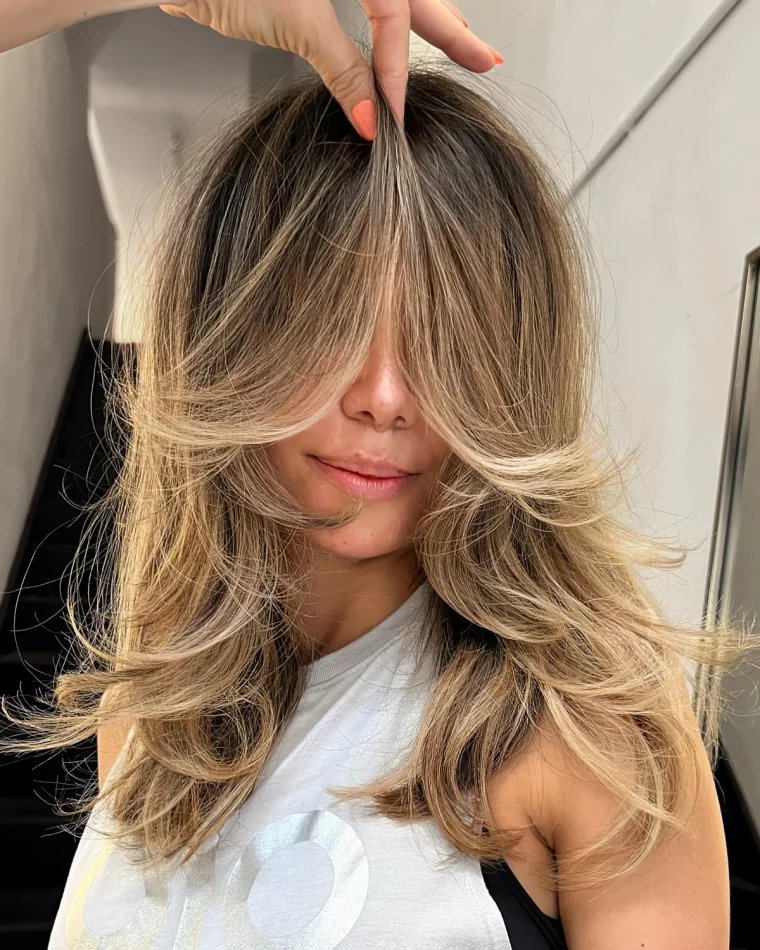 balayage blond racines fonces debardeur blanc coupe cheveux longs