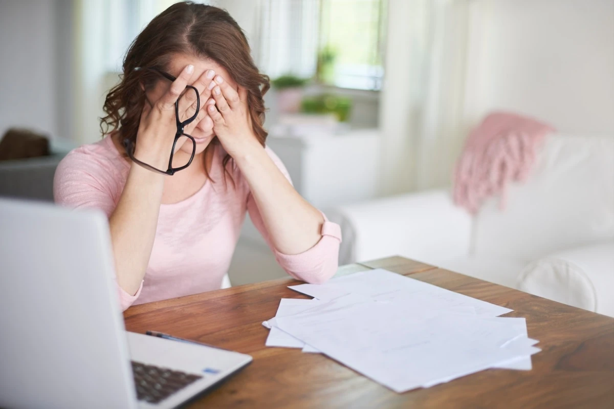 femme fatigue pression papier documents bureau ordinateur travail lunettes vue
