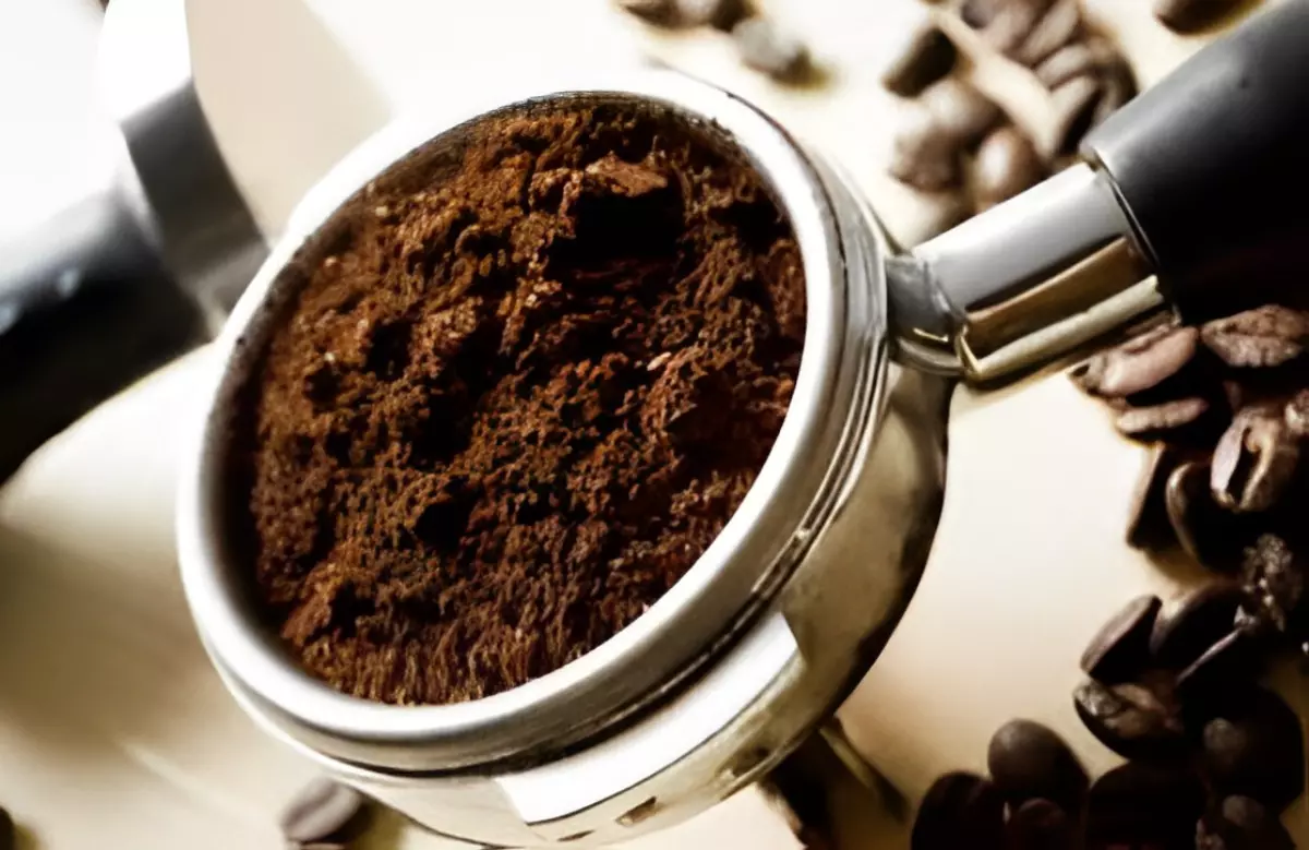 marc du cafe dans le bac d une machine a cafe sur fond des graines de café entiers