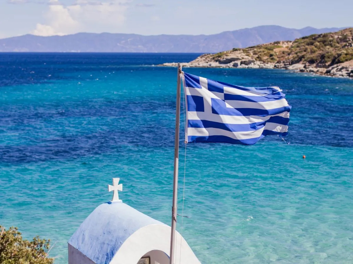 Un drapeau grec et la mer vous attendent pour des vacances