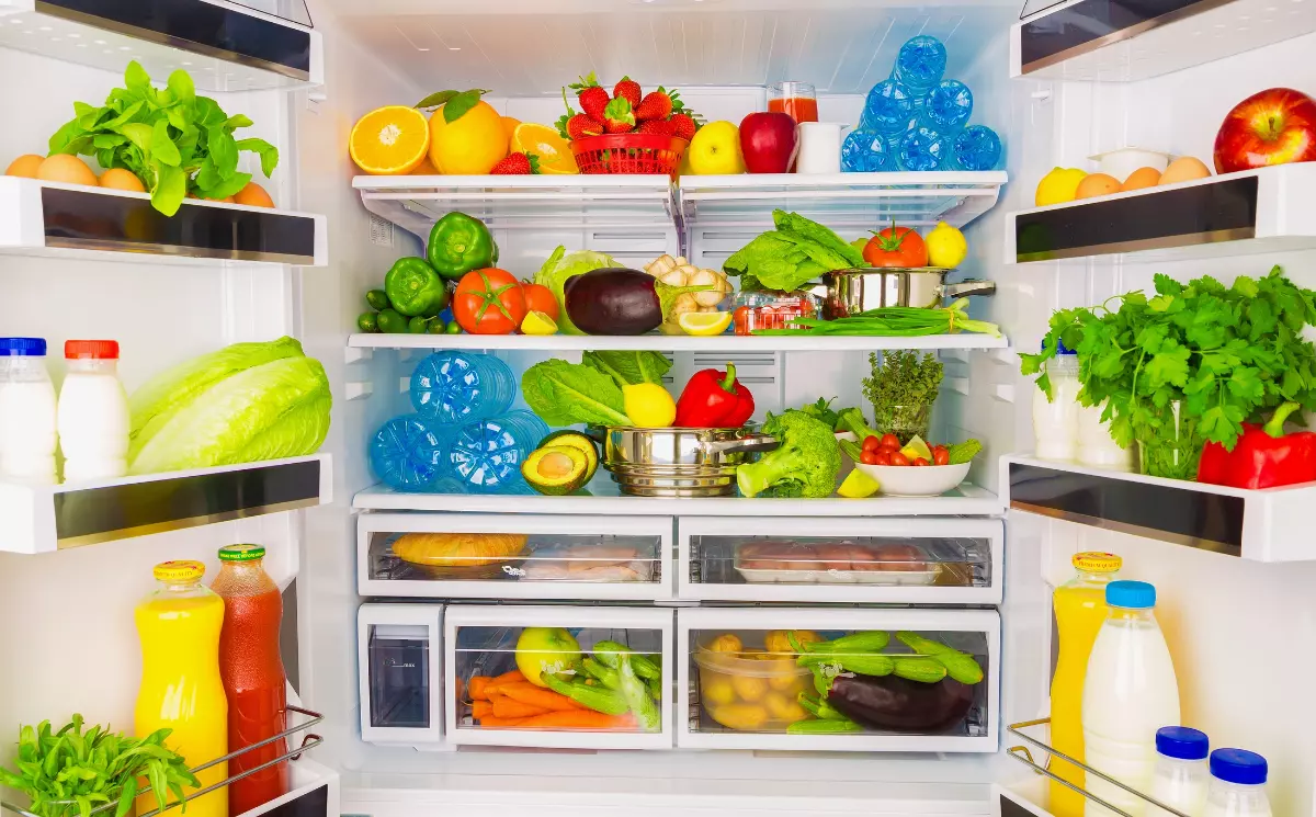 refrigerateur plein de fruits et legumes avec une double porte ouverte
