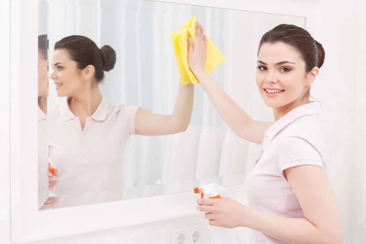 bien nettoyer sa maison tous les jours femme nettoie miroir