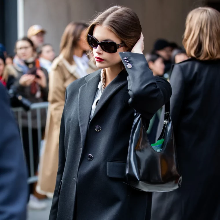 manteau en laine noir lunettes de soleil et sac a main