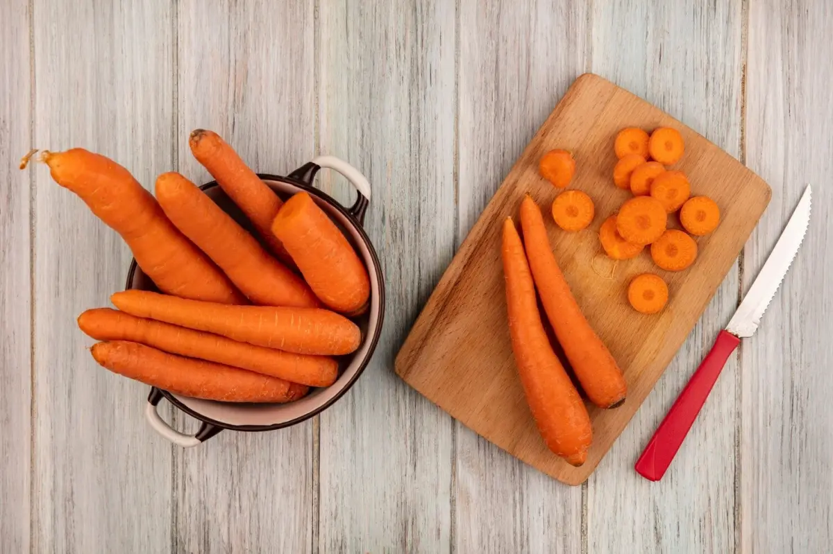 planche decouper bois couteau casserole carottes sans fanes rondelles