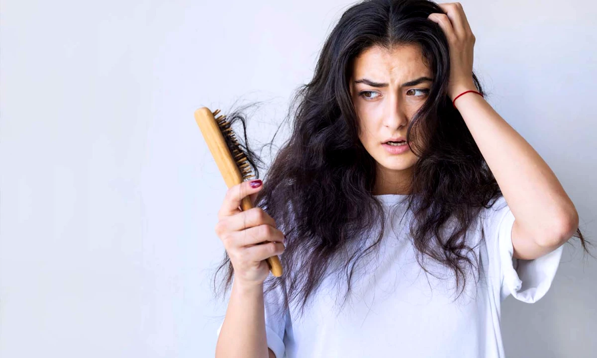 que faire si je perd beaucoup de cheveux femme brune brosse en bois