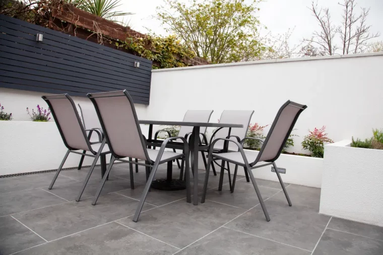 salon de jardin metal table chaises dalles aspect beton plantes exterieur