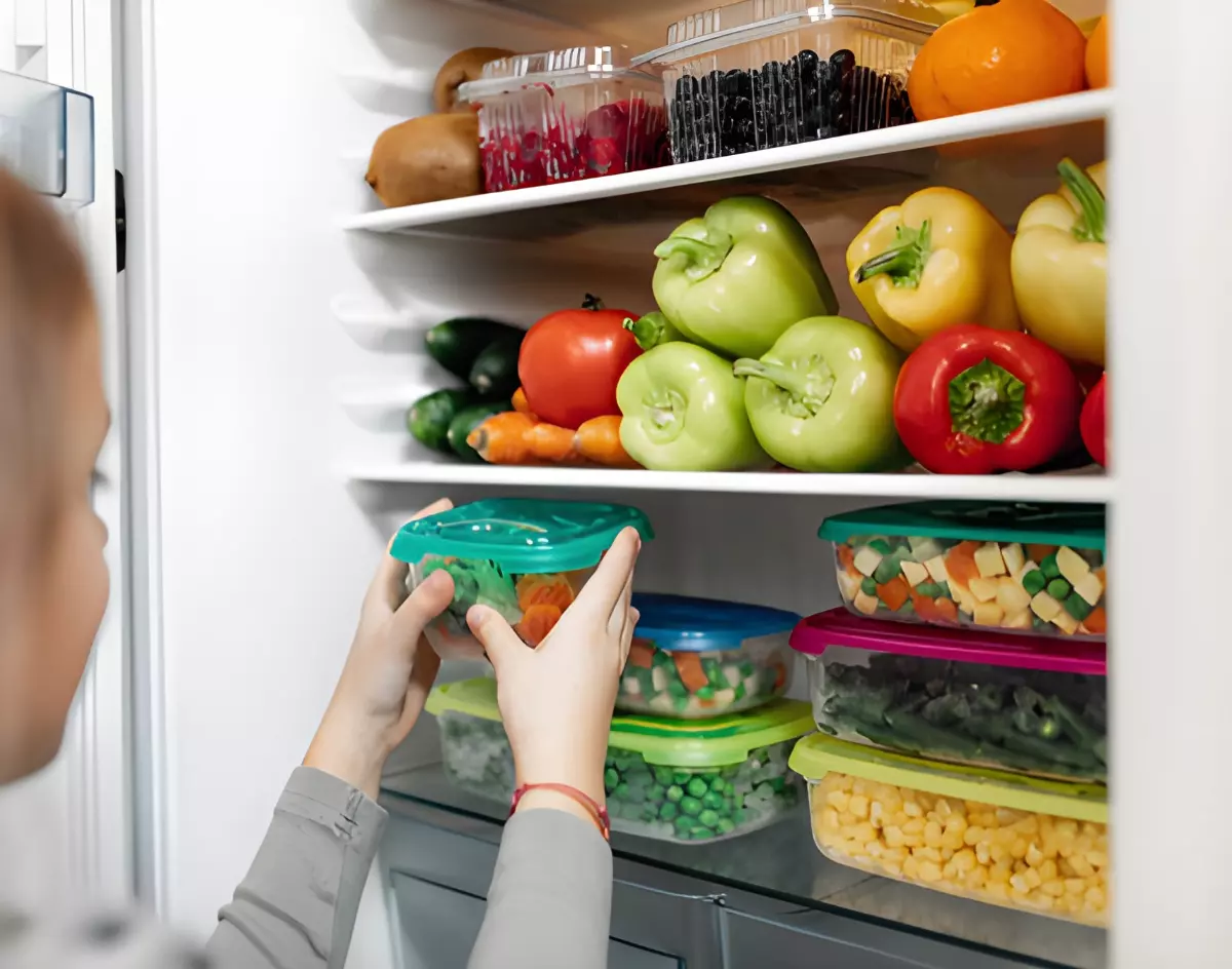boites remplies de legumes decoupees sur les etageres du refrigerateur et des legumes entiers au dessus