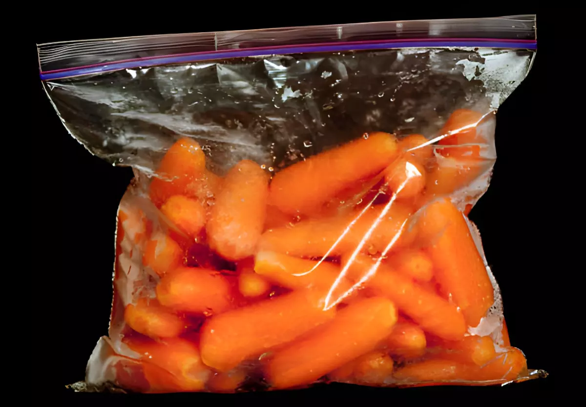 carottes nettoyees et lavees dans un sachet plastique sur fond noir