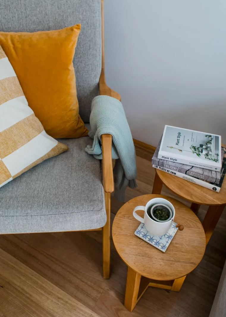 fauteuil en gris coussins moutarde tables d appoit en bois