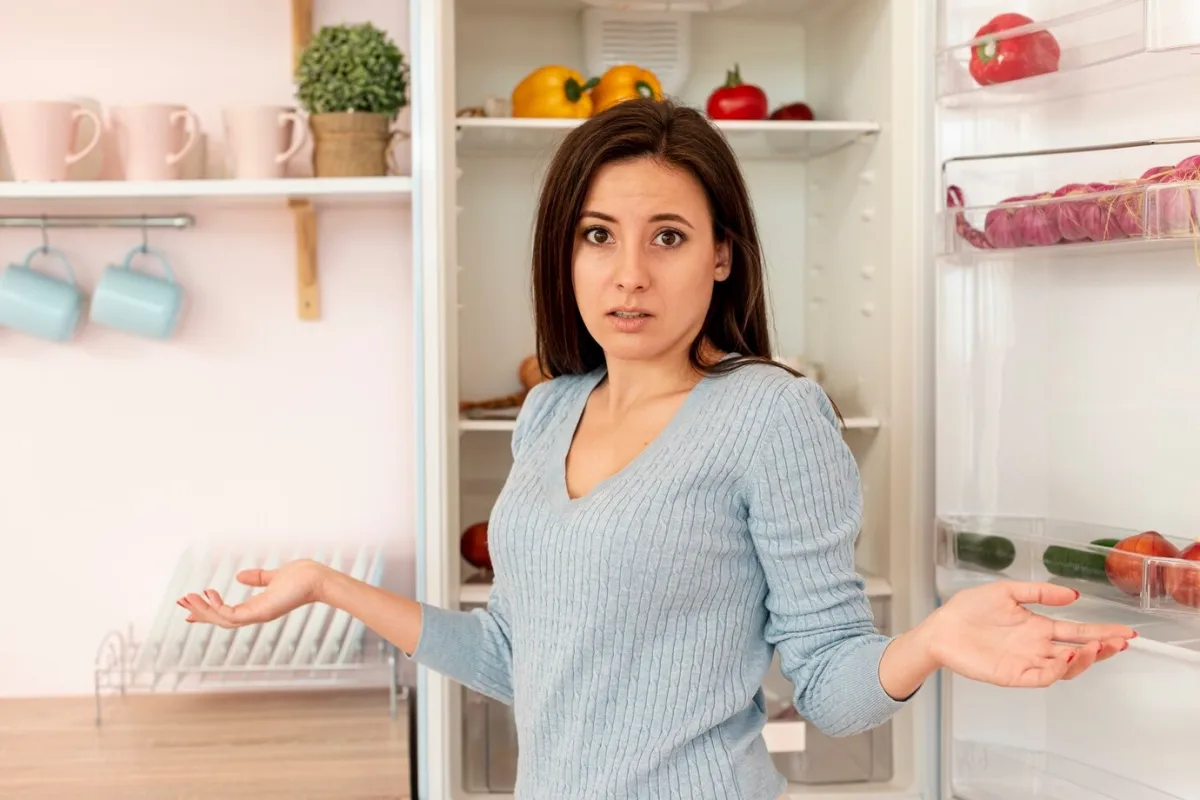 femme devant frigo ouvert porte legumes collection tasses de cafe