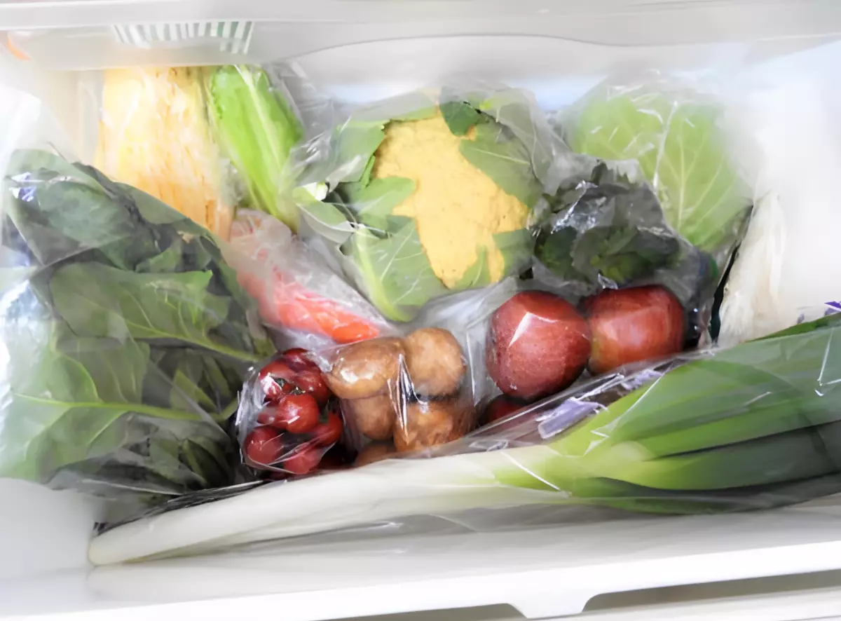 legumes a feuilles pommes tomates cerises et pommes de terre dans des sacs plastiques dans un compartiment du refrigerateur