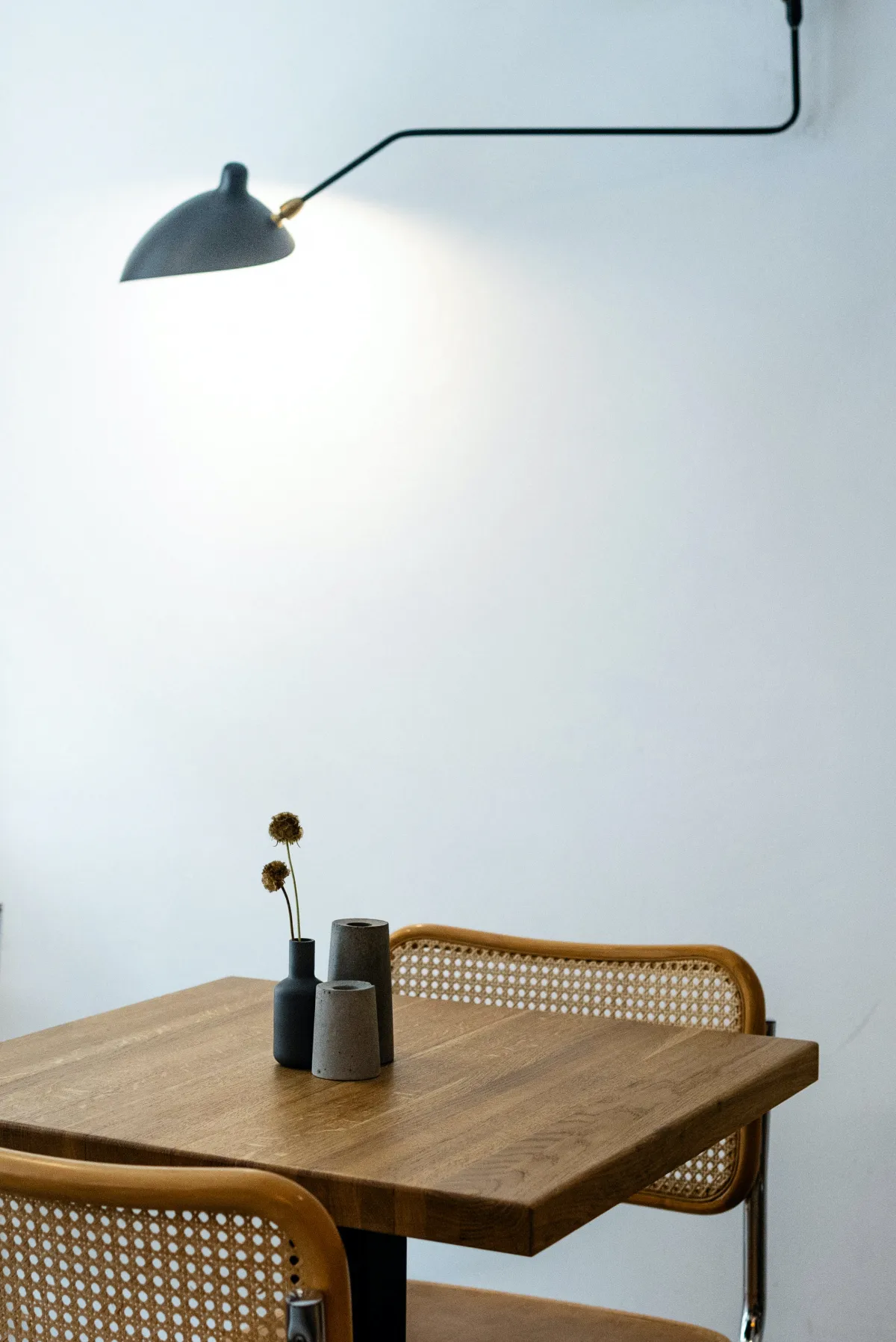 mur blanc lampadaie suspendu table et deux chaises