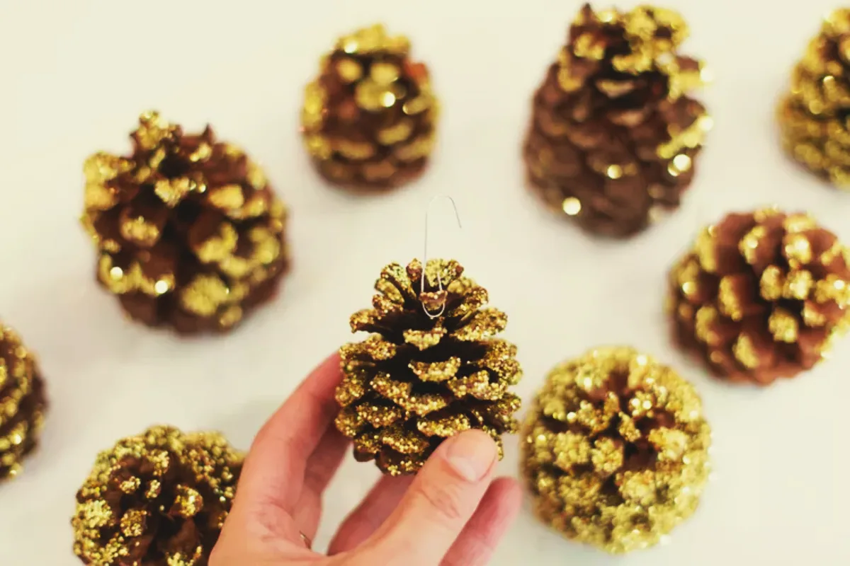 ornements décoration avec des pommes de pin pour noel avec des paillettes or