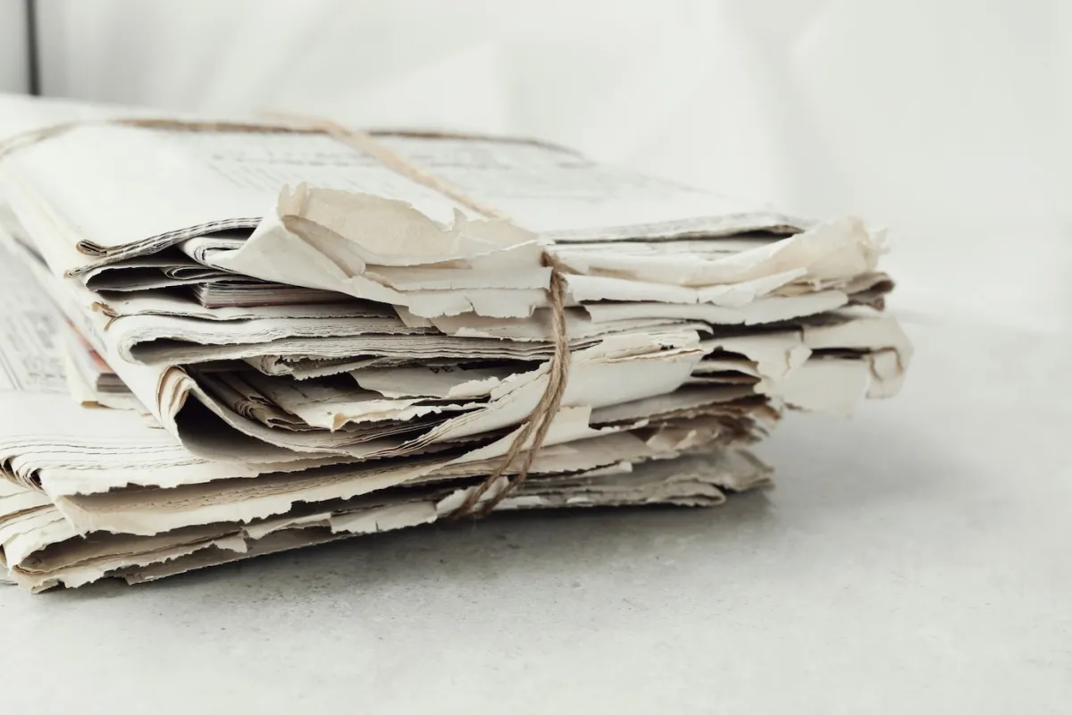 tas vieux journaux ficelle surface table blanche pages papier