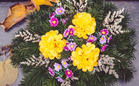 vue de dessus d un arrangement floral avec des branches de sapin trois fleurs jaunes et des petites fleurs violettes