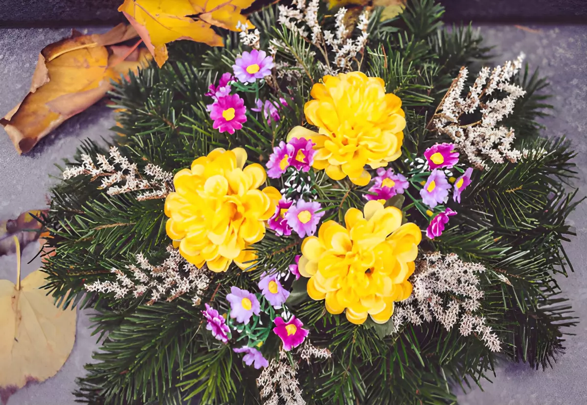 vue de dessus d un arrangement floral avec des branches de sapin trois fleurs jaunes et des petites fleurs violettes