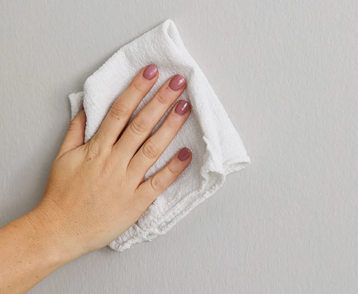 comment se débarrasser de la graisse incrustée main essuie unmur blanc