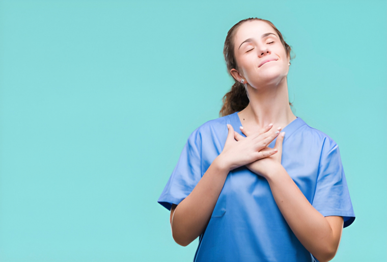 femme avec une blouse bleue tient ses mains sur sa poitrine et sourit avec les yeux fermes sur fond vert