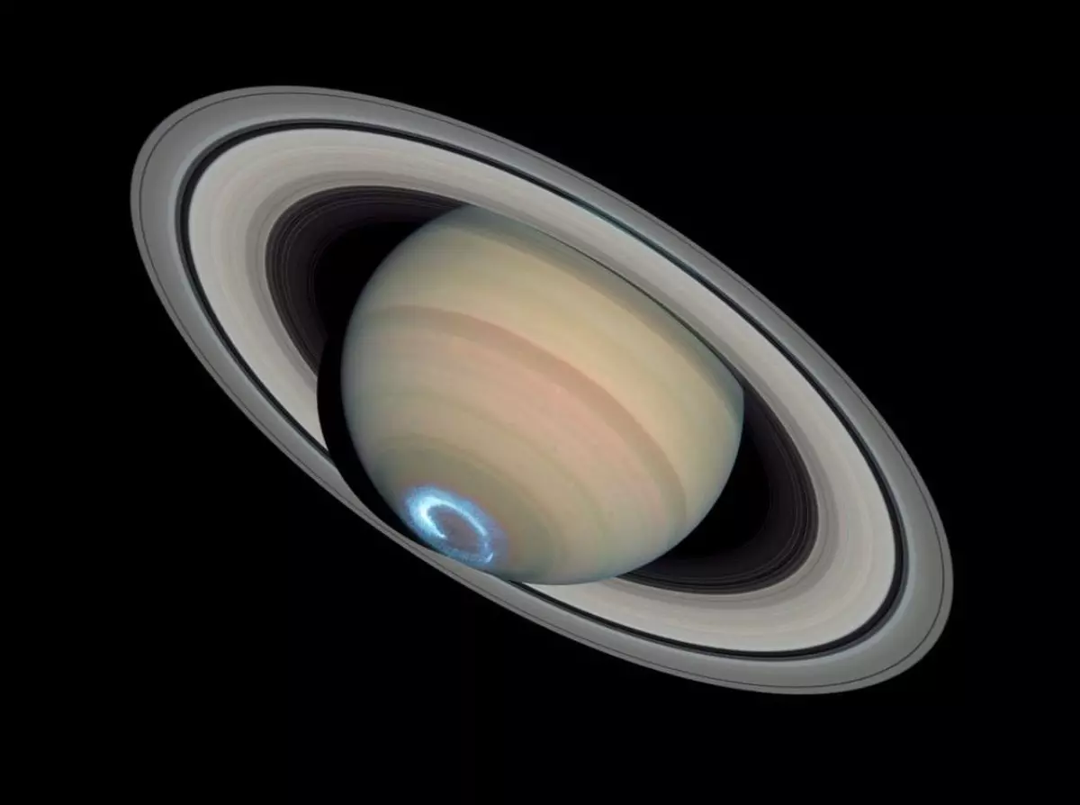 la planete saturne avec son anneau sur fond noir et un rayonnement bleu sur son pole