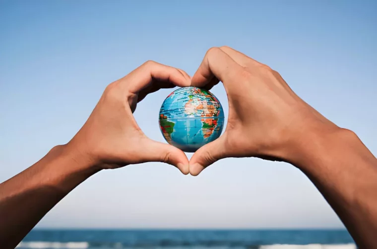 les bras d homme forment un coeur autour du globe terrestre si fond bleu