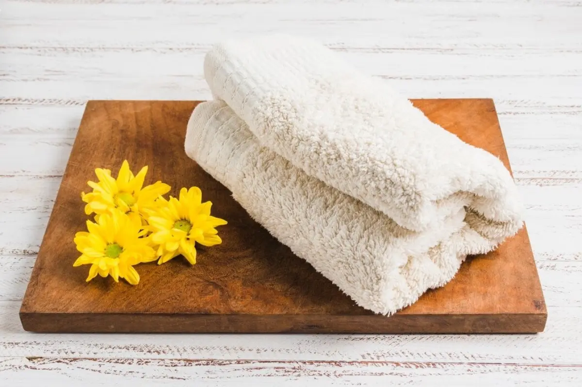 planche decouper bois fleurs jaunes serviette de bain beige surface bois
