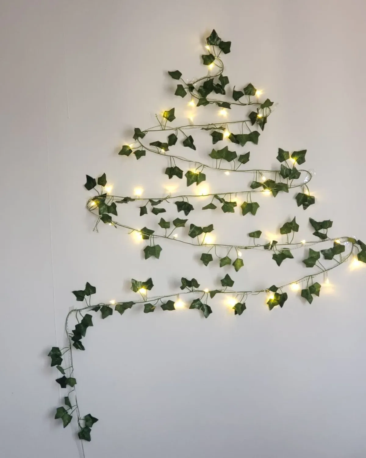 sapin de noel alternatif guirlande luminese a feuilles vertes mur blanc