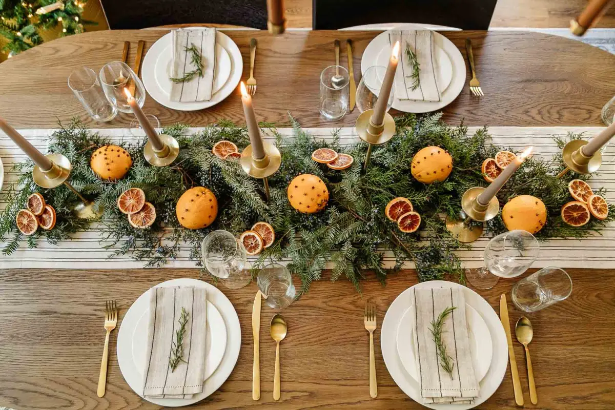 table bois chemin tissu blanc guirlande de noel en branches de sapin tranches orange