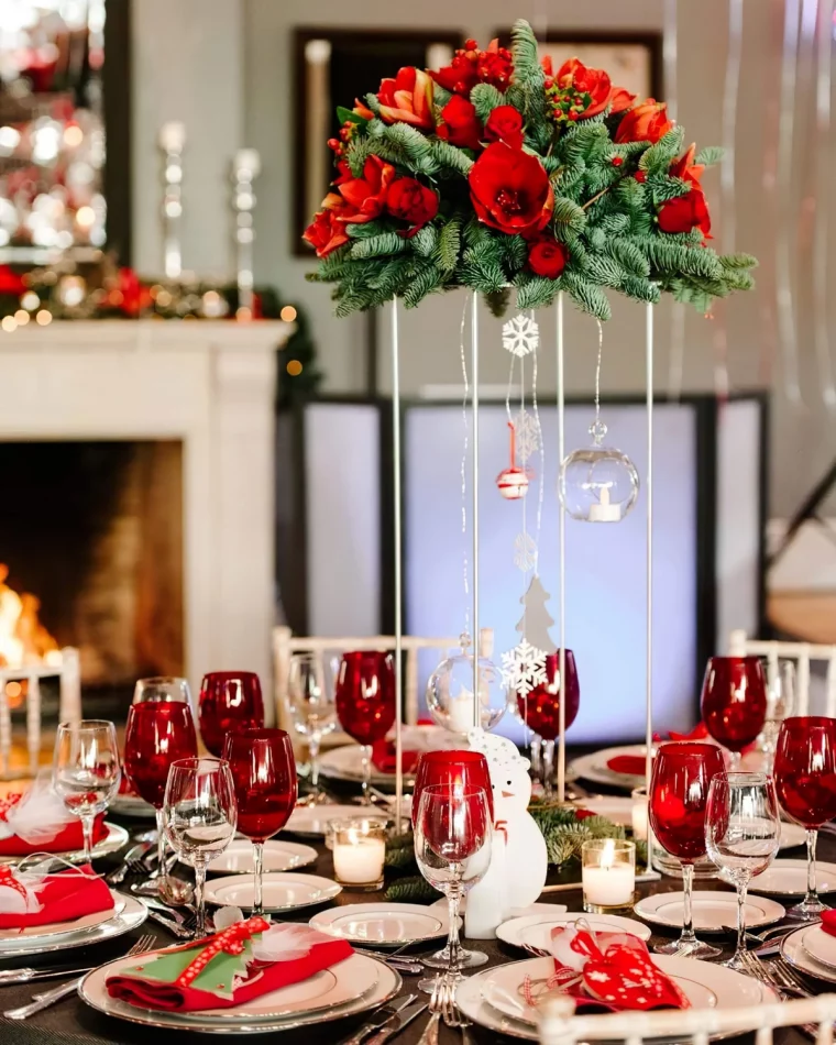 verres rouges centre table suspendu composition branches fleurs rouges assiettes blanches